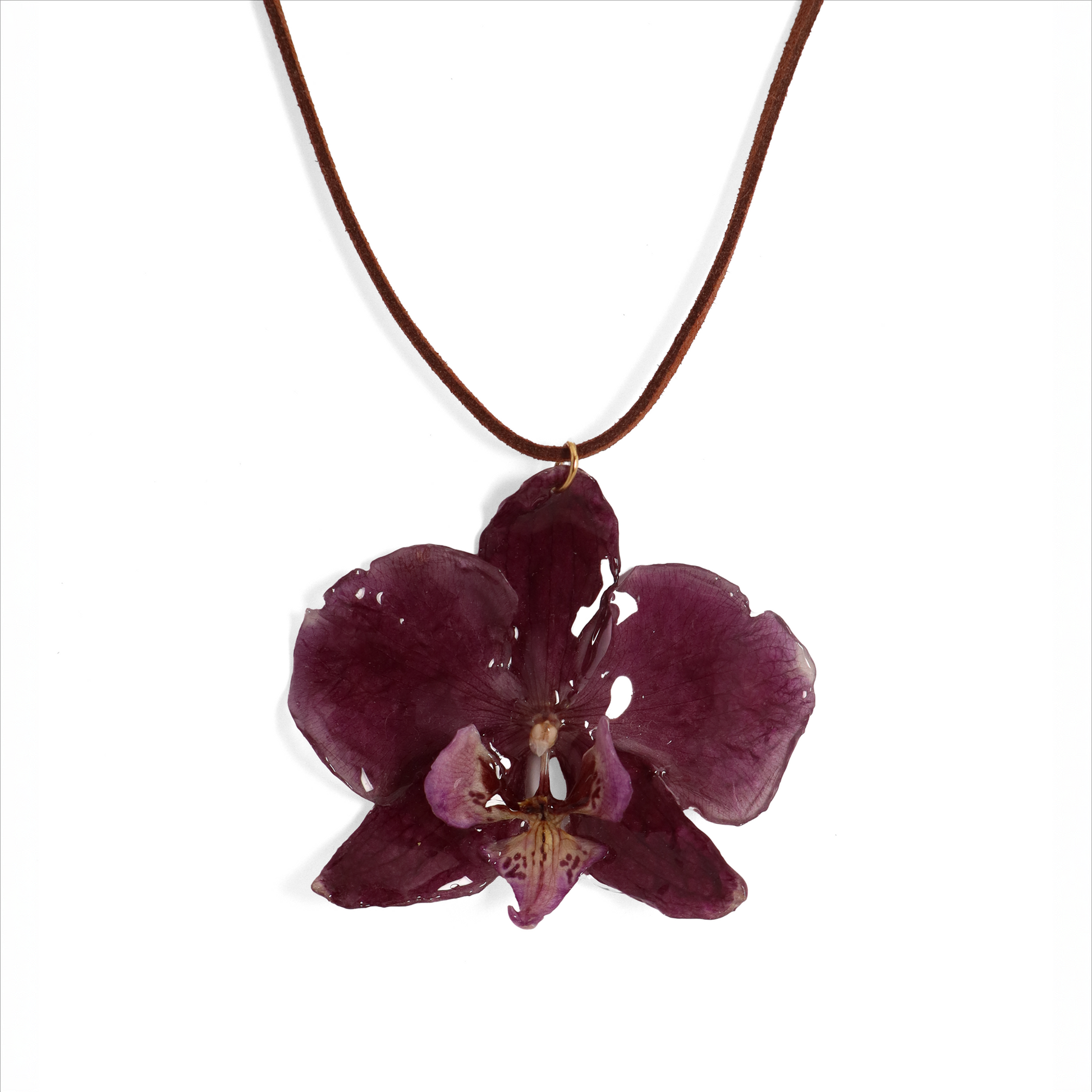 Choker violeta artesanal con flor de orquídea natural sobre fondo blanco
