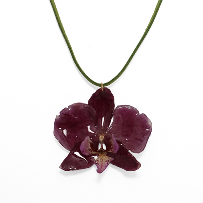 Choker violeta artesanal con flor de orquídea natural sobre fondo blanco
