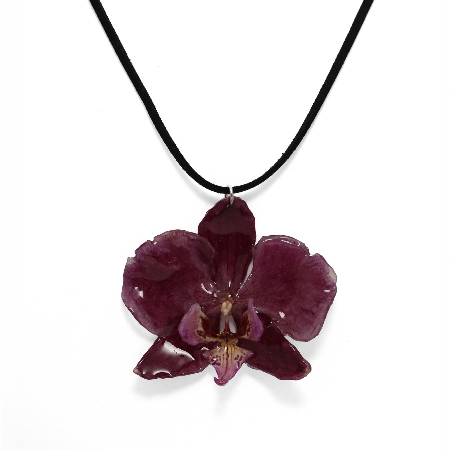 Choker violeta artesanal con flor de orquídea natural sobre fondo blanco
