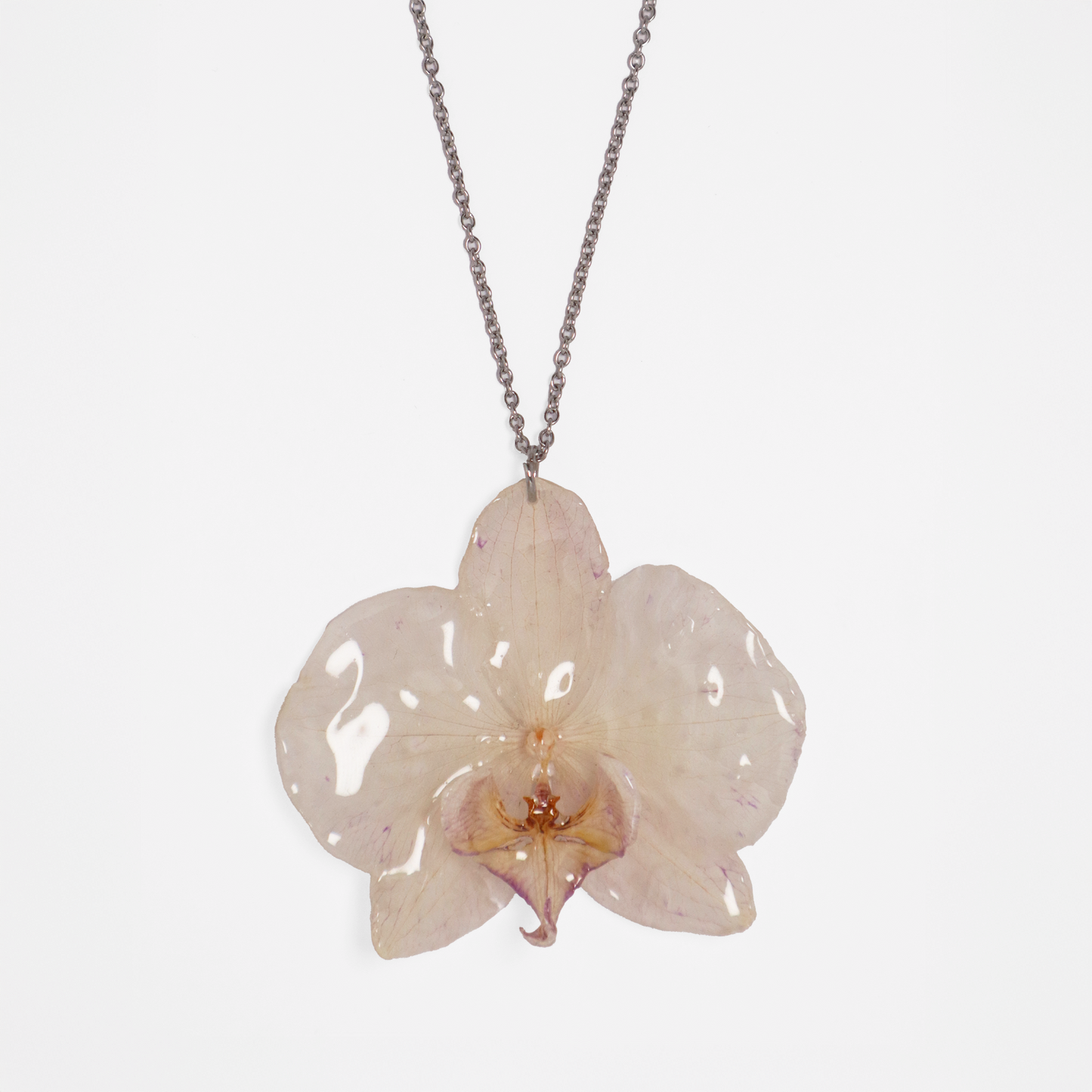 Collar crema, joyería de diseño artesanal con flor de orquídea natural sobre fondo blanco
