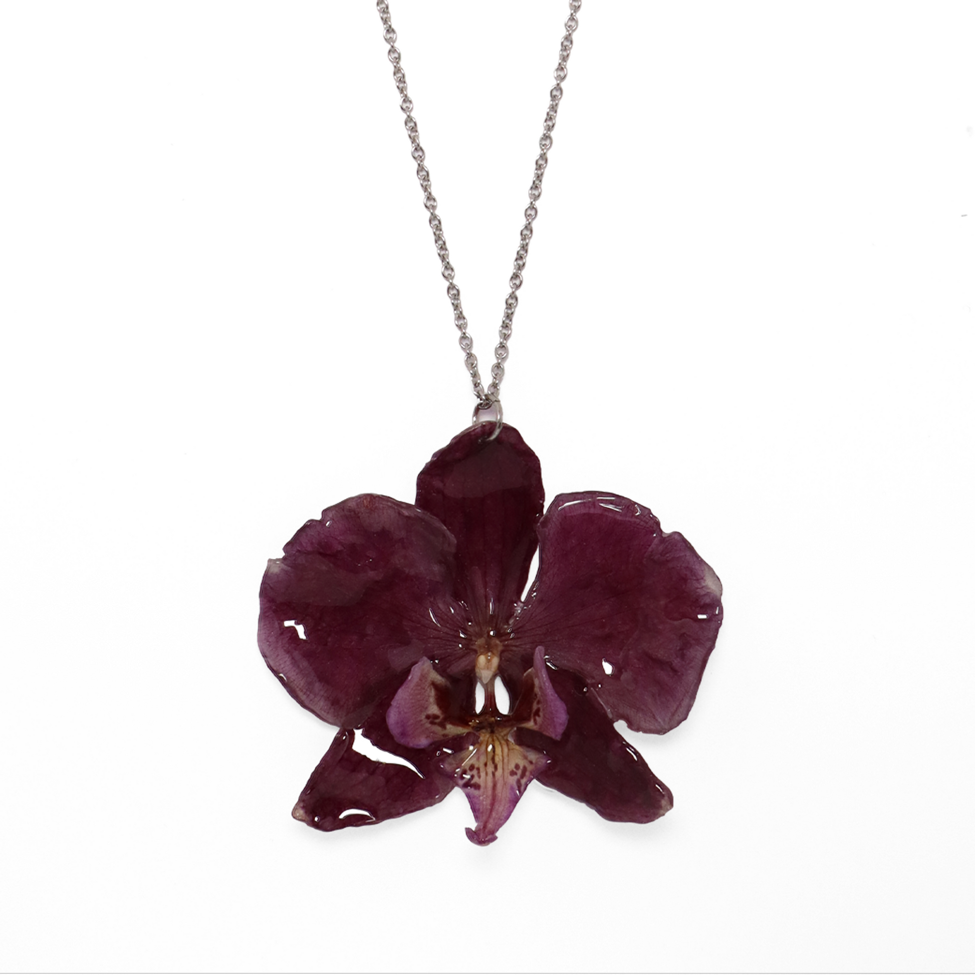 Collar violeta, joyería de diseño artesanal con flor de orquídea natural sobre fondo blanco
