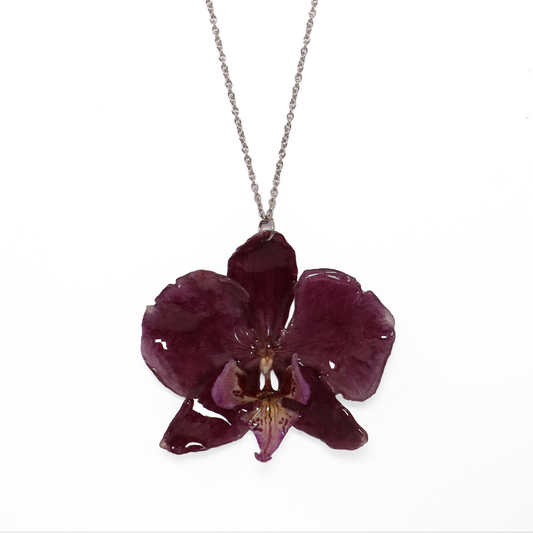Collar violeta, joyería de diseño artesanal con flor de orquídea natural sobre fondo blanco
