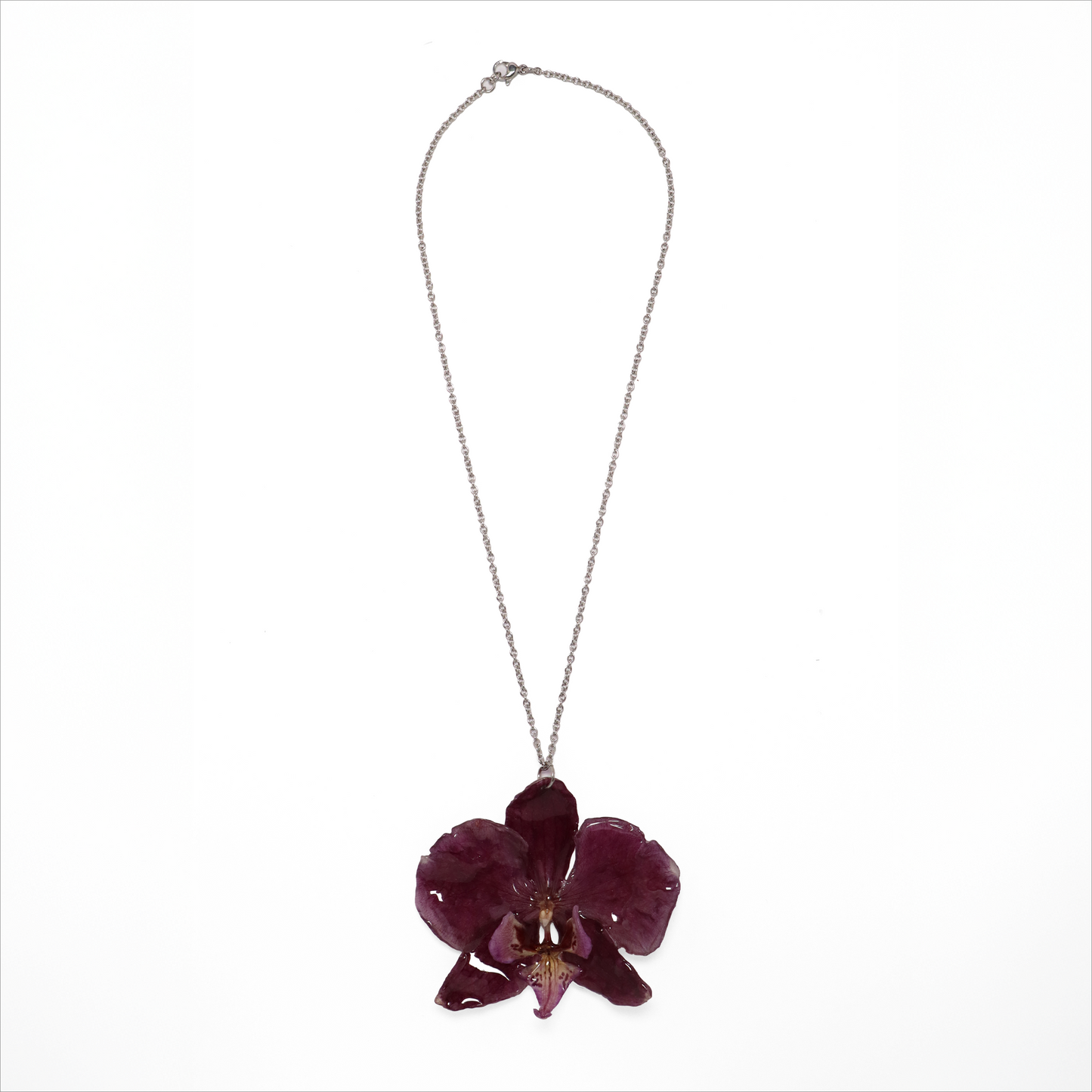Collar violeta, joyería de diseño artesanal con flor de orquídea natural sobre fondo blanco
