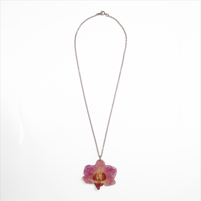 Collar rosado pequeño, joyería de diseño artesanal con flor de orquídea natural sobre fondo blanco
